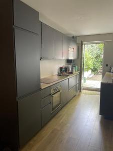 uma cozinha com electrodomésticos em aço inoxidável e piso em madeira em Appartement proche de paris avec jardin em Meudon