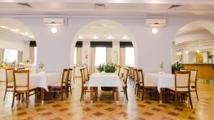 jadalnia z białymi stołami i krzesłami w obiekcie Hotel Łazienkowski w Warszawie