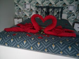 斯帕的住宿－L'écurie gîte chambre，一张有两个红色天鹅的睡床,看起来像心