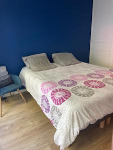 um quarto com uma cama com um cobertor roxo e branco em Appartement proche de paris avec jardin em Meudon