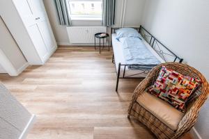 Habitación pequeña con cama y silla en Steger-Hüs Wohnung 15, en Rantum