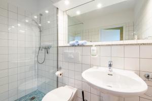 a bathroom with a sink and a toilet and a shower at Steger-Hüs Wohnung 25 in Rantum +17 photos