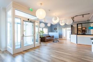 a living room with glass doors and a couch at Steger-Hüs Wohnung 25 in Rantum