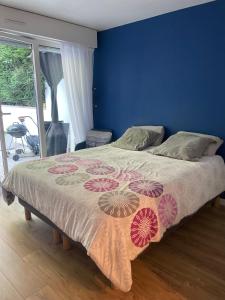 uma cama num quarto com uma parede azul em Appartement proche de paris avec jardin em Meudon