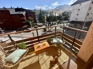 een balkon met een tafel en stoelen bij APARTAMENTO súper céntrico, con vistas a pistas y Wifi in Formigal