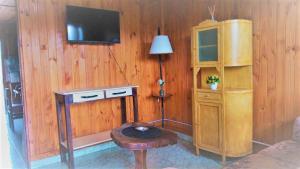 a room with a wooden wall with a tv and a stool at Cabaña Carmela in Garupá