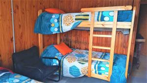 a room with two bunk beds and a chair at Cabaña Carmela in Garupá