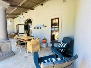 a patio with a wooden table and chairs at The Merino Guest House in Beaufort West