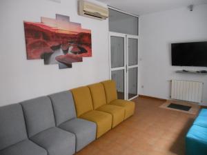 Residencia Universitaria Reuniver Burjassot في Benimamet: غرفة معيشة مع أريكة وتلفزيون بشاشة مسطحة