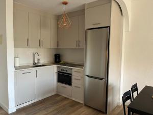 eine Küche mit weißen Schränken und einem Edelstahlkühlschrank in der Unterkunft Casa Balcon del Mar 2 in Costa Del Silencio