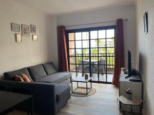 ein Wohnzimmer mit einem Sofa, einem TV und einem Balkon in der Unterkunft Casa Balcon del Mar 2 in Costa Del Silencio