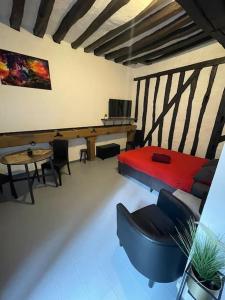 een kamer met een bureau en een tafel en stoelen bij Le Brumby - Internet Netflix draps serviettes café in Joigny