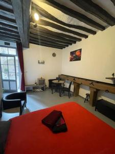 a room with a table and a bed with a red rug at Le Brumby - Internet Netflix draps serviettes café in Joigny