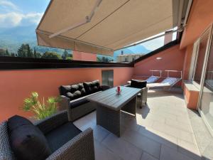 ピゾーニェにあるAros Mountain Lake Iseo Hospitaliyのテーブルと椅子のある屋外パティオ