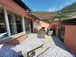 a balcony with two benches and an umbrella at Aros Mountain Lake Iseo Hospitaliy in Pisogne