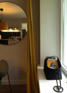 a bag sitting on a table in front of a mirror at Showroom Central Apartment in Šiauliai