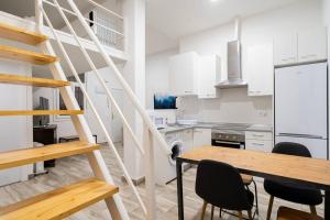 een keuken met witte kasten en een houten tafel met stoelen bij Nice apartment in Chamberí PON23 in Madrid