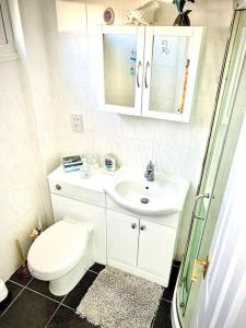 Un baño blanco con inodoro y lavabo. en Classic Seaside Holiday Home in Hemsby, en Hemsby