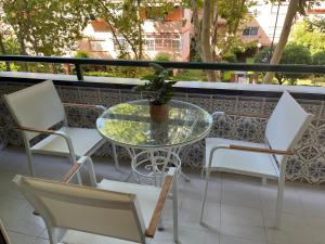 a glass table and chairs on a balcony at Marian’s House in Fuengirola