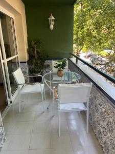 a balcony with a glass table and two chairs at Marian’s House in Fuengirola