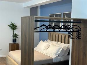 1 dormitorio con 1 cama con cabecero de madera en Scandinavian Apartments AL, en Tirana
