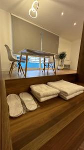 Habitación con mesa, almohadas y suelo de madera. en Scandinavian Apartments AL en Tirana