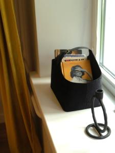 a bag sitting on a window sill with a book at Showroom Central Apartment in Šiauliai