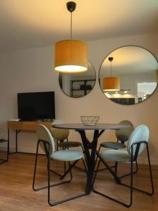a dining room with a table and chairs and a mirror at Showroom Central Apartment in Šiauliai