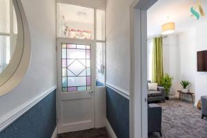 a hallway with a door with a stained glass window at 5 Double Bedrooms with Ensuites - Teesside House TSAC in Redcar