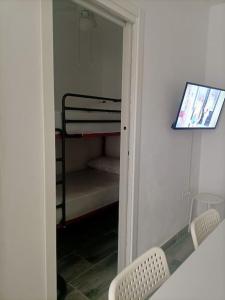 een kamer met 2 stoelen en een slaapkamer met een stapelbed bij Castelar in Rota