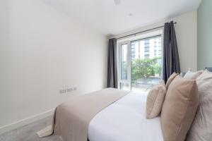a bedroom with a white bed and a window at The River Thames Collection in London