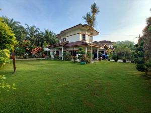 a house with a large yard with green grass at 3 Bedrooms Villa with Private Pool in Port Dickson