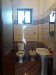 une salle de bains avec toilettes et lavabo dans l'établissement Vila Lika Durres, à Durrës