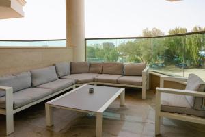 a living room with a couch and a coffee table at Golf Residence By Sun and View in Eilat