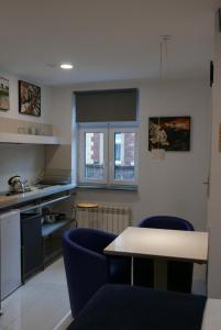 una cocina con 2 sillas azules y una mesa en ROOMS BYTOM, en Bytom