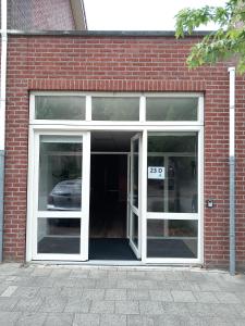 une porte ouverte d'un bâtiment en briques avec une voiture à l'intérieur dans l'établissement Yerseke Maarten & Hanh, à Yerseke