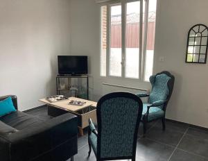 a living room with a couch and a table and chairs at Maison tout confort in Corbie