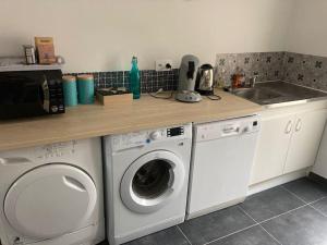 a kitchen with a washing machine and a sink at Maison tout confort in Corbie