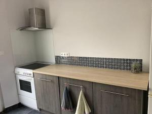a kitchen with a stove and a counter top at Maison tout confort in Corbie