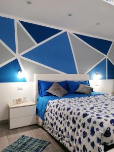 AcriにあるB&B La Rosa dei Ventiの青と白の壁のベッドルーム1室、ベッド1台が備わります。