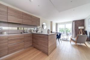 a kitchen with wooden cabinets and a dining room at The River Thames Collection in London