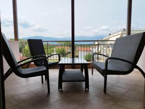 eine Terrasse mit 3 Stühlen und einem Tisch auf dem Balkon in der Unterkunft Studio Loft Aridea in Aridea