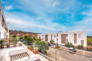 Cet appartement dispose d'un balcon offrant une vue sur les bâtiments. dans l'établissement Illi Taghazout T3 Luxe Piscine 4 or 5 Px, à Taghazout