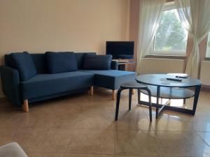 a living room with a blue couch and a table at Apartamenty Nowa Tuchorza 17 in Tuchorza Nowa +17 photos
