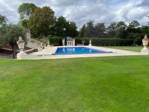 a swimming pool in the middle of a yard at ABRIDGE PANORAMIC House in Theydon Bois