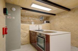 a small kitchen with a sink and a stove at Private rooms with bathroom in Valletta in Valletta +50 photos
