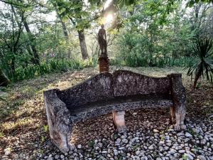 una statua seduta sopra una panchina di pietra di Villa Capannina a Novi Ligure