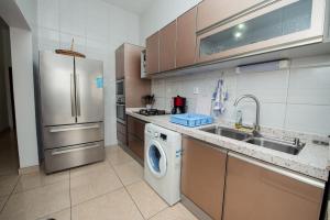 a kitchen with a washing machine and a sink at Appartement Charmant et Lumineux in Pointe-Noire