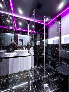 a black bathroom with two sinks and purple lighting at Black Pearl Luxury Apartment in Ventspils +15 photos