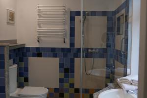 een badkamer met een douche, een toilet en een wastafel bij ROOMS BYTOM in Bytom